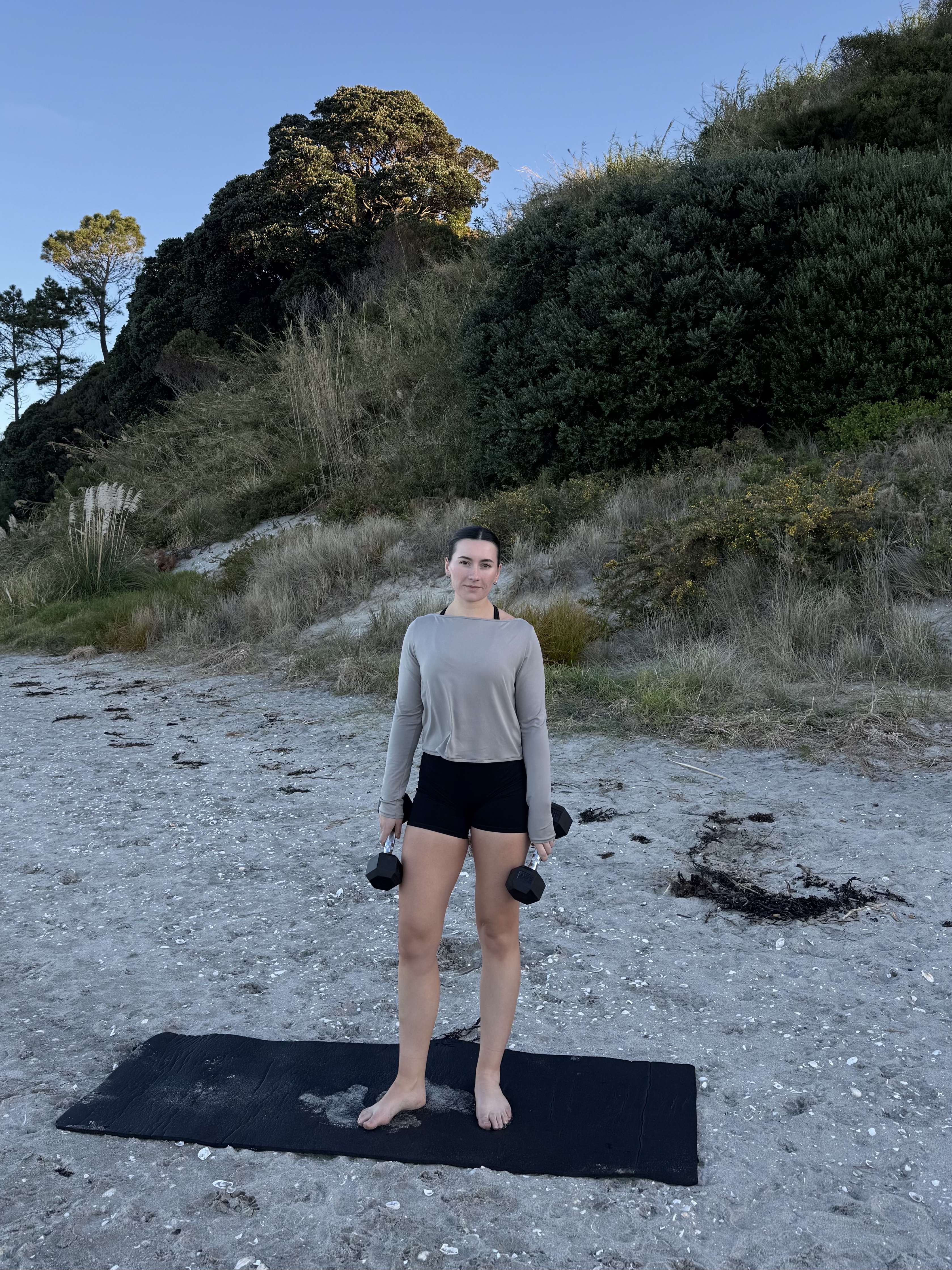 Kate on the beach with dumbbells